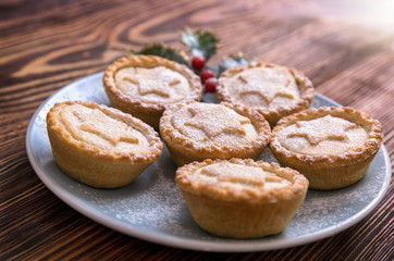 Obraz na płótnie Canvas Homemade, british Mince Pies for Christmas on a blue plate on wooden table