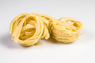 Uncooked and raw tagliatelle isolated on white.