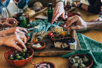 hands picking food on a party table - obrazy, fototapety, plakaty