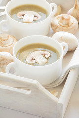 Two bowl with traditional mushroom soup cream on white table cloth