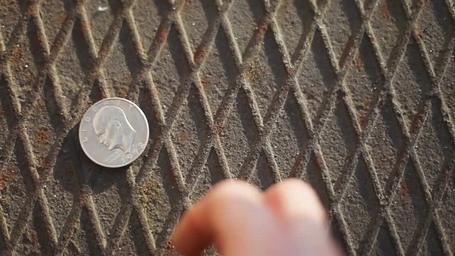one dollar coin being rolled rolling rolls metal surface eagle liberty slow motion international valuta exchange finance commerce affluence money business man male hand taking up closeup shoot rate