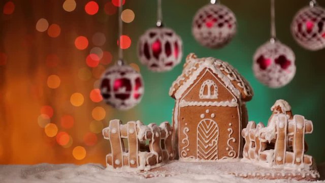 Christmas setting with gingerbread house and beautiful baubles against blurry blinking xmas lights background - copyspace