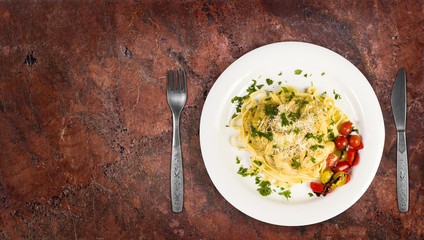 Fresh handmade tagliatelle pasta with forest mushrooms, parsley and cherry tomatoes salad on granite kitchen countertop. Top view with copy space added.