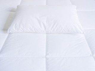 Fototapeta na wymiar Closeup of white pillow and topper bed.