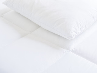 Closeup of white pillow and topper bed.