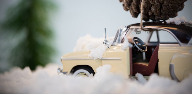 Toy car carrying pine cone on fake snow - Powered by Adobe