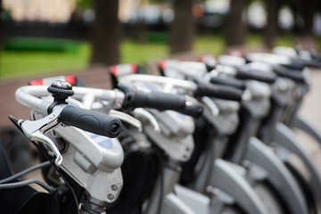 Row of city parked bikes for rent on sidewalk