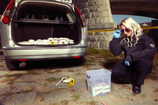 Police staff stock to plastic case drugs found in car under the bridge