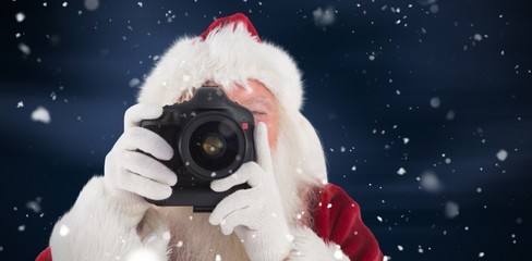 Composite image of santa is taking a picture