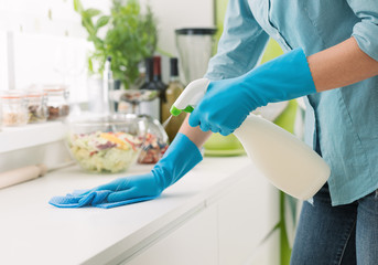 Woman cleaning with a spray detergent - obrazy, fototapety, plakaty