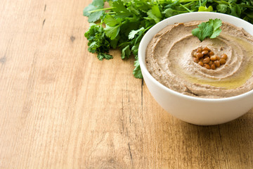 Lentil hummus in bowl on wood
