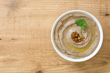 Lentil hummus in bowl on wood