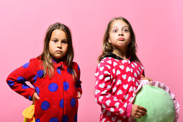 Kids with surprised faces hold green and yellow pillows