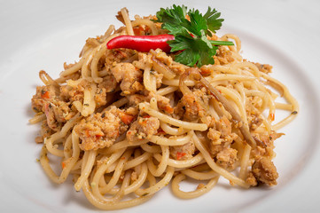 Spicy pork spaghetti on a white plate