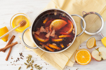 Cooked mulled wine in a saucepan on a white table