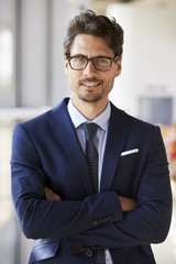 Portrait of young professional man in suit, arms crossed