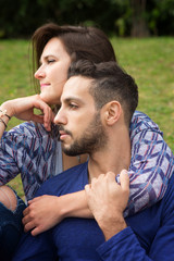 young beautiful couple sitting outside in Park