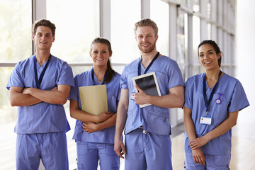 Group portrait of healthcare workers in hospital corridor