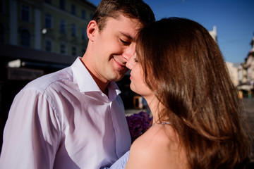 Tender touches of a pretty couple standing somewhere in the city