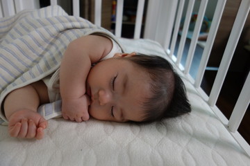 Baby sleeping while sucking his finger, boy, 4 months after birth