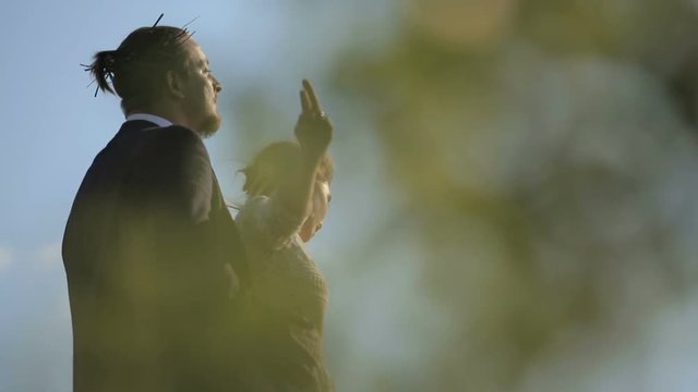 beautiful young couple on the background meadows. loving woman dances before the groom outdoors