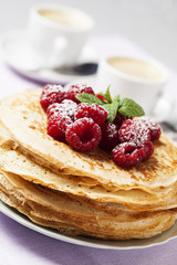 Stack of Russian-style pancakes with raspberries