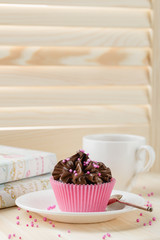 Chocolate cupcake with sprinkles in pink cup