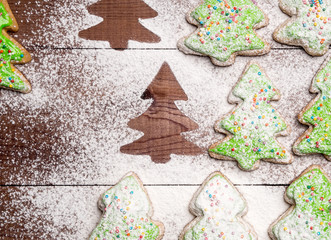 fir-trees made of gingerbread sprinkled with powdered sugar. Silhouettes of Christmas trees on a wooden background
