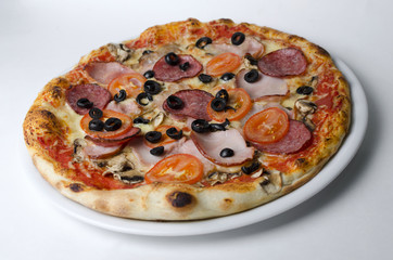 Pizza with ham salami and mushrooms on a white plate
