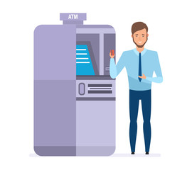 Bank employee, next to atm terminal, holds card in hand.