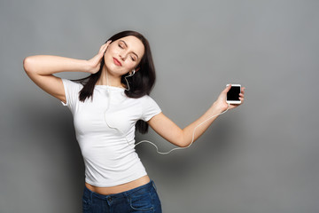 Woman with closed eyes enjoying music in earphones