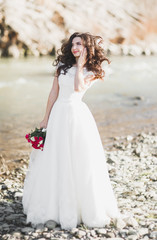 Fototapeta na wymiar Portrait of stunning bride with long hair posing with great bouquet