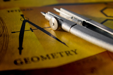 Compass on a notebook with the words geometry