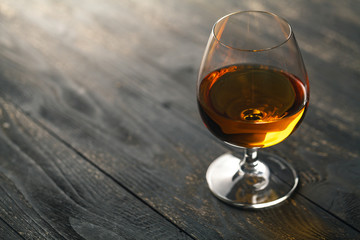 Glass of whiskey on a wooden background