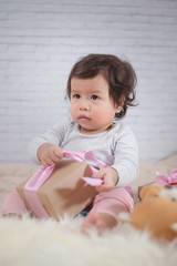 Sweet Beautiful baby girl wrapping ribbon on beautiful white furry.Newborn baby concept. Happy New Year.