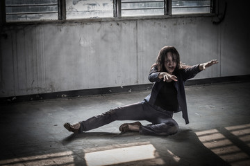 Female zombie crouching on the floor, Halloween concept.