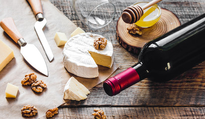red wine with cheese and honey on wooden background