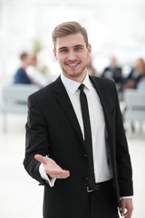 confident young businessman holds out his hand for greeting