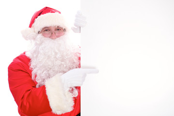 Kind Santa Claus pointing in white blank sign, isolated on white background