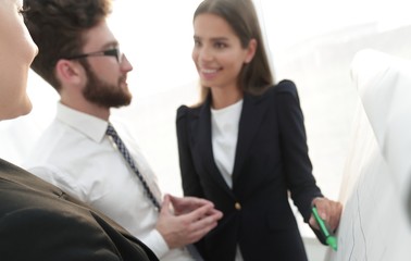 business woman pointing with a marker on the flipchart