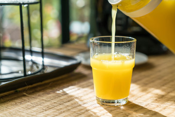 pouring orange juice in a glass