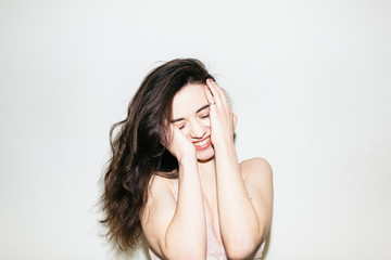 Portrait of attractive smiling woman against a white wall