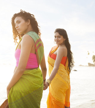 Women wearing saris on beach. Sri Lanka.