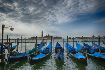 Fototapeta na wymiar Early morning view on gondolas peers grand channel Venice Italy