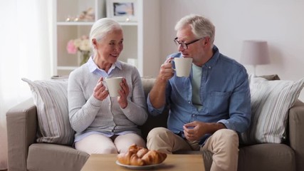 happy senior couple drinking coffee at home - Powered by Adobe