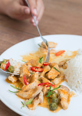 Red pork curry (Panang) with rice in white plate on wooden background, Thai food