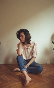 Beautiful young girl sitting on the floor in her bedroom