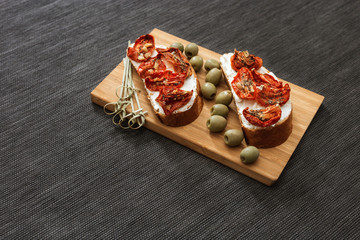 Bruschetta with sun-dried red tomatoes Italian delicious food on dark background with copy space.