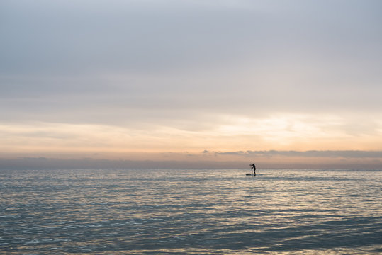 Surfer in the sea at sunset