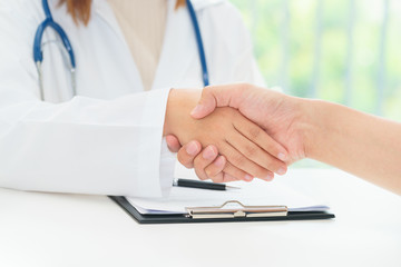 Doctor and patient are shaking hands, medical diagnosis concept.
